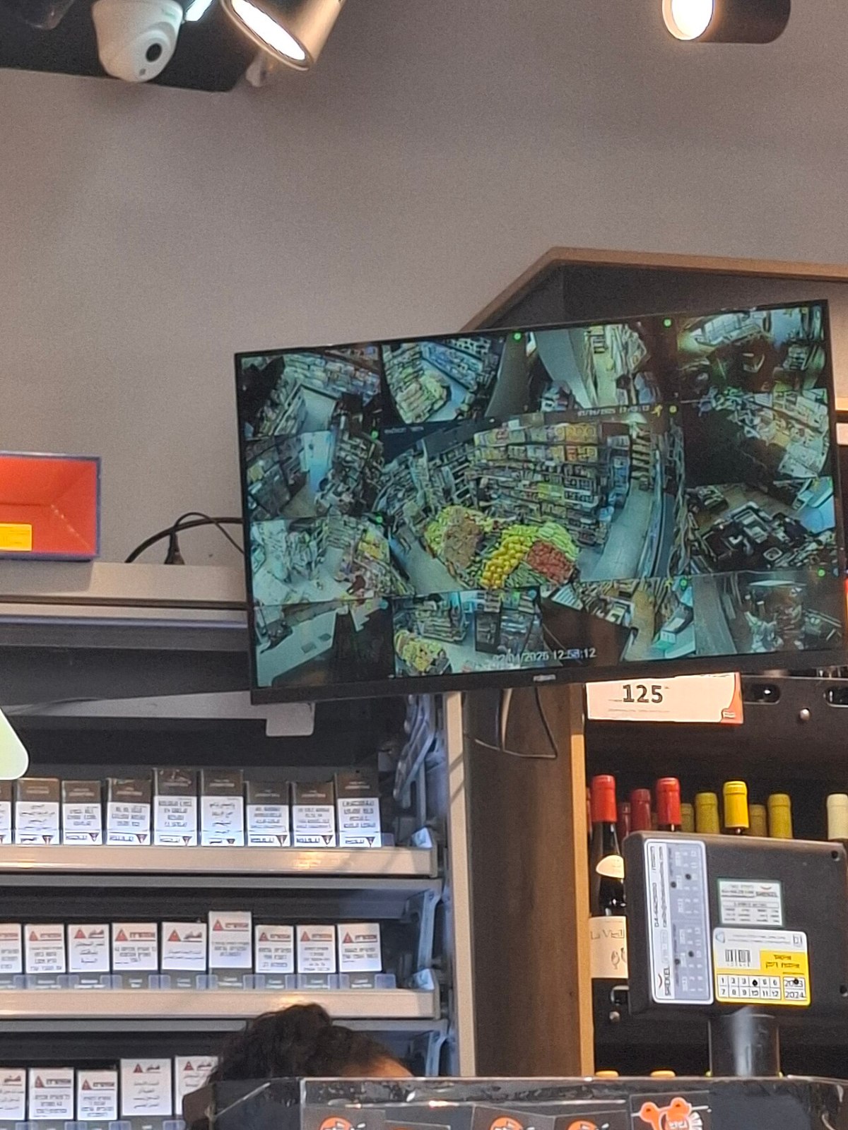 Mağazada kamera görüntülerini gösteren monitör ve tavandaki kubbe kamera
